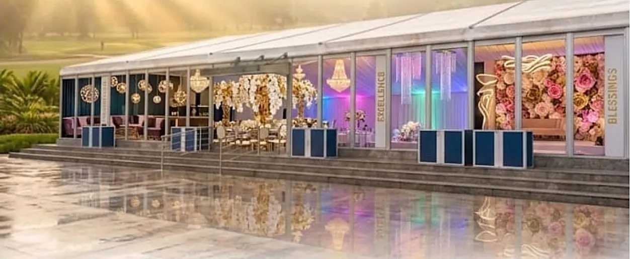 The marquee dressed with chandeliers and a flower wall